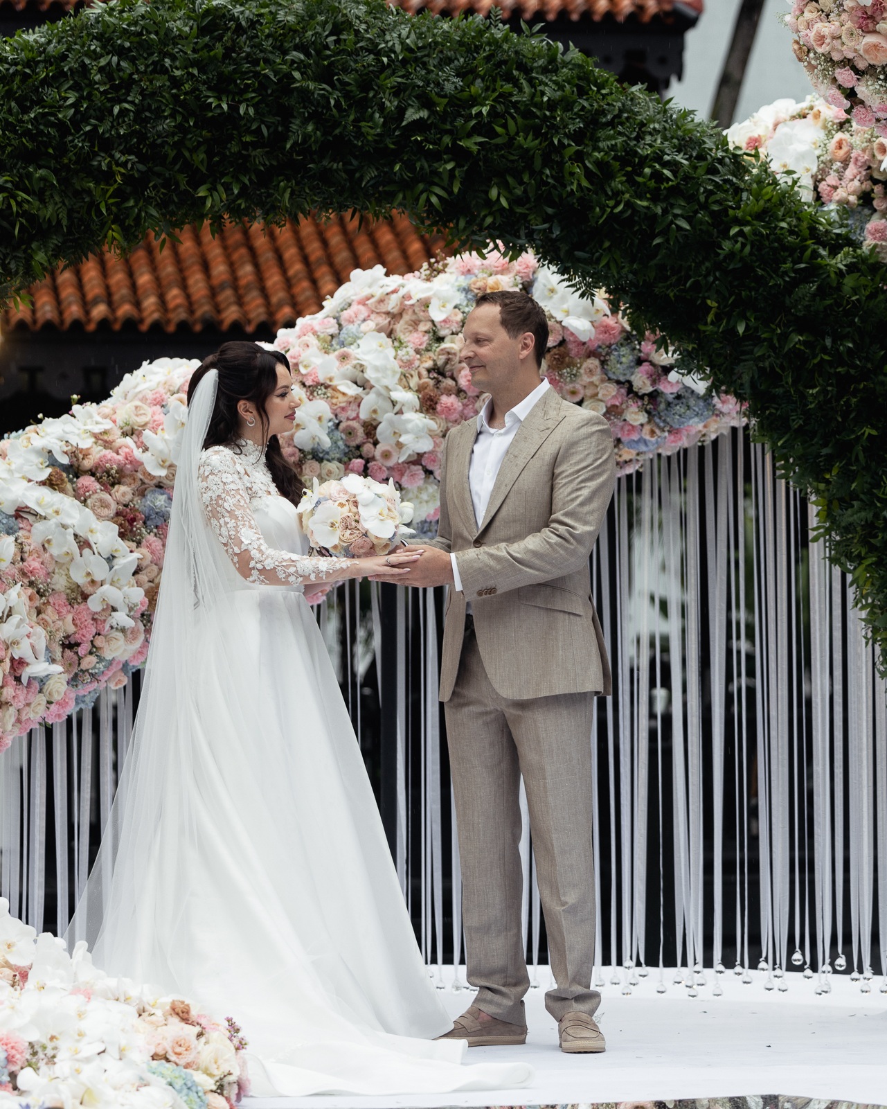 Luxury wedding floral installation โ white grand piano submerged in thousands of blush and pink roses and ranunculus โ Alina & Slava, Raffles Hotel Singapore, S$250k bespoke floral design by Tomas De Bruyne and Create Your Story