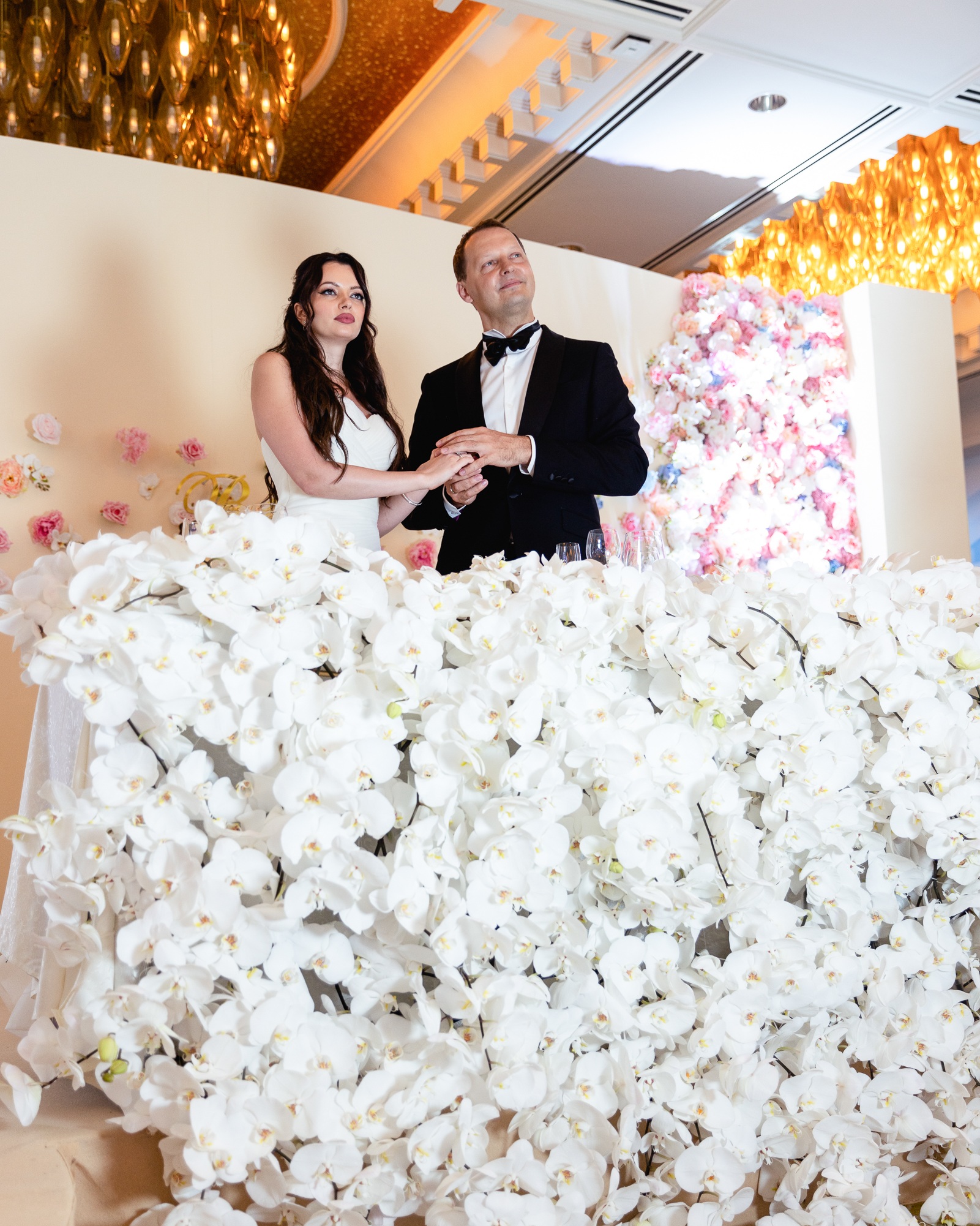 Luxury wedding floral installation โ white grand piano submerged in thousands of blush and pink roses and ranunculus โ Alina & Slava, Raffles Hotel Singapore, S$250k bespoke floral design by Tomas De Bruyne and Create Your Story
